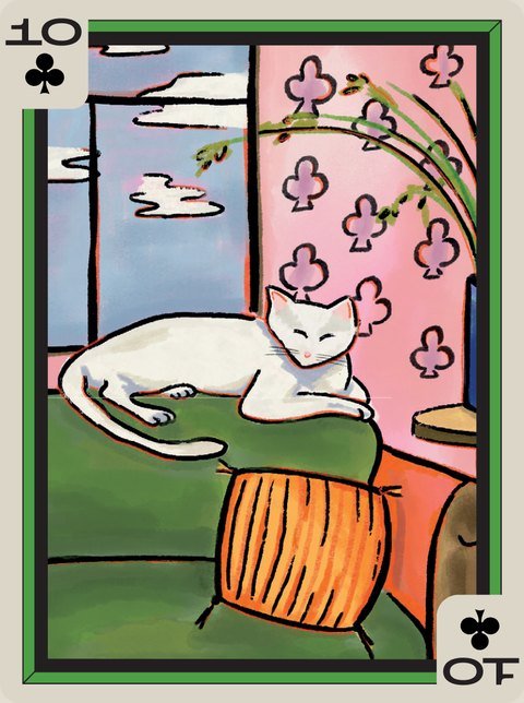10 of Clubs: A white cat asleep on a green chair beside a window.