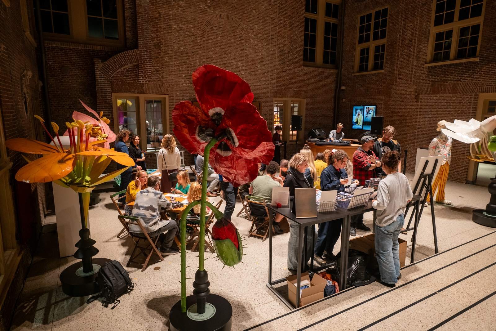 The Achterplaats seen from the steps, with giant red and yellow paper flowers in front of the playing tables.