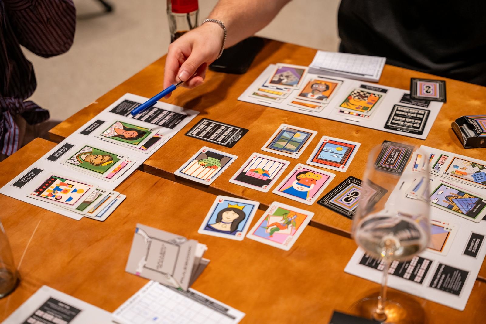 Overhead view of a game in progress: painted cards laid out in Exhibitions on the player boards.
